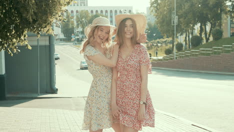 two women friends posing on a city street