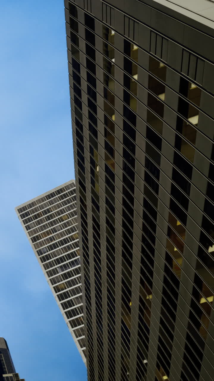 Rascacielos modernos se elevan contra un cielo azul claro en un paisaje urbano.