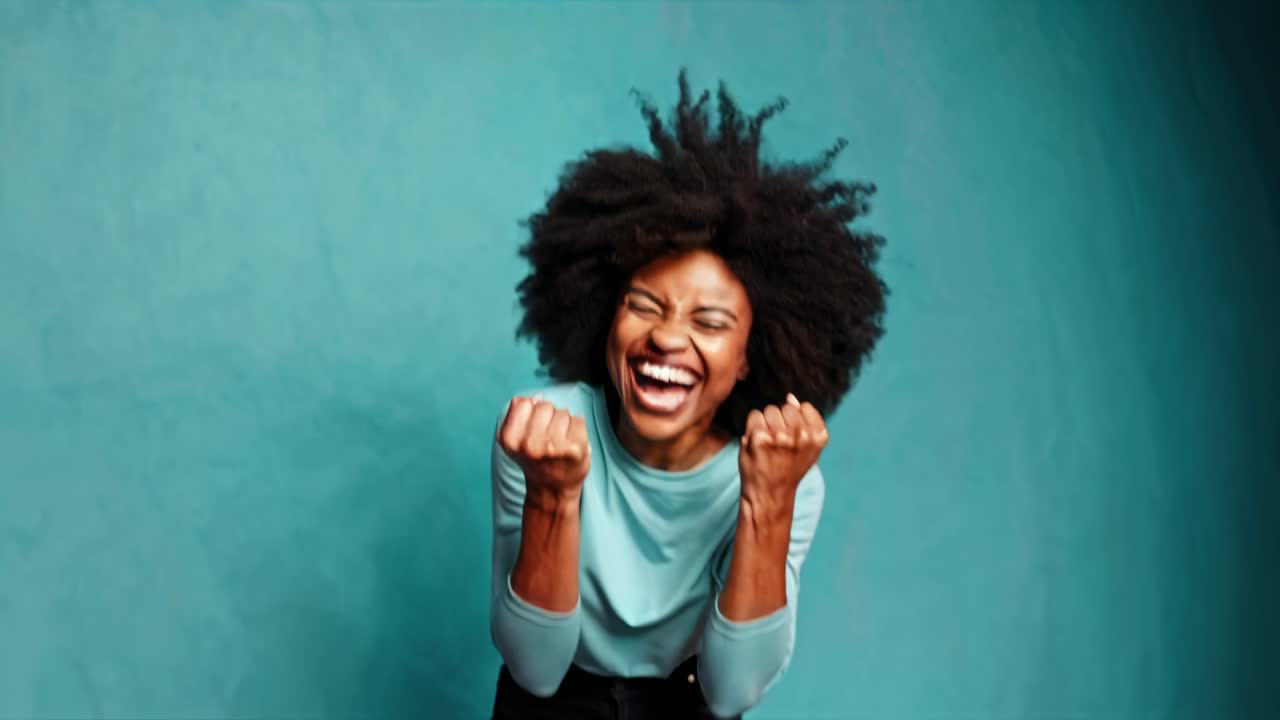 A joyful woman with clenched fists celebrates success. Captured from a front angle, the vibrant