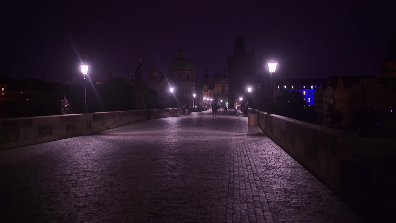 Prague At Night - Walking On The Dark Illuminated Charles Bridge In Prague, Czech Republic At Night - dolly shot