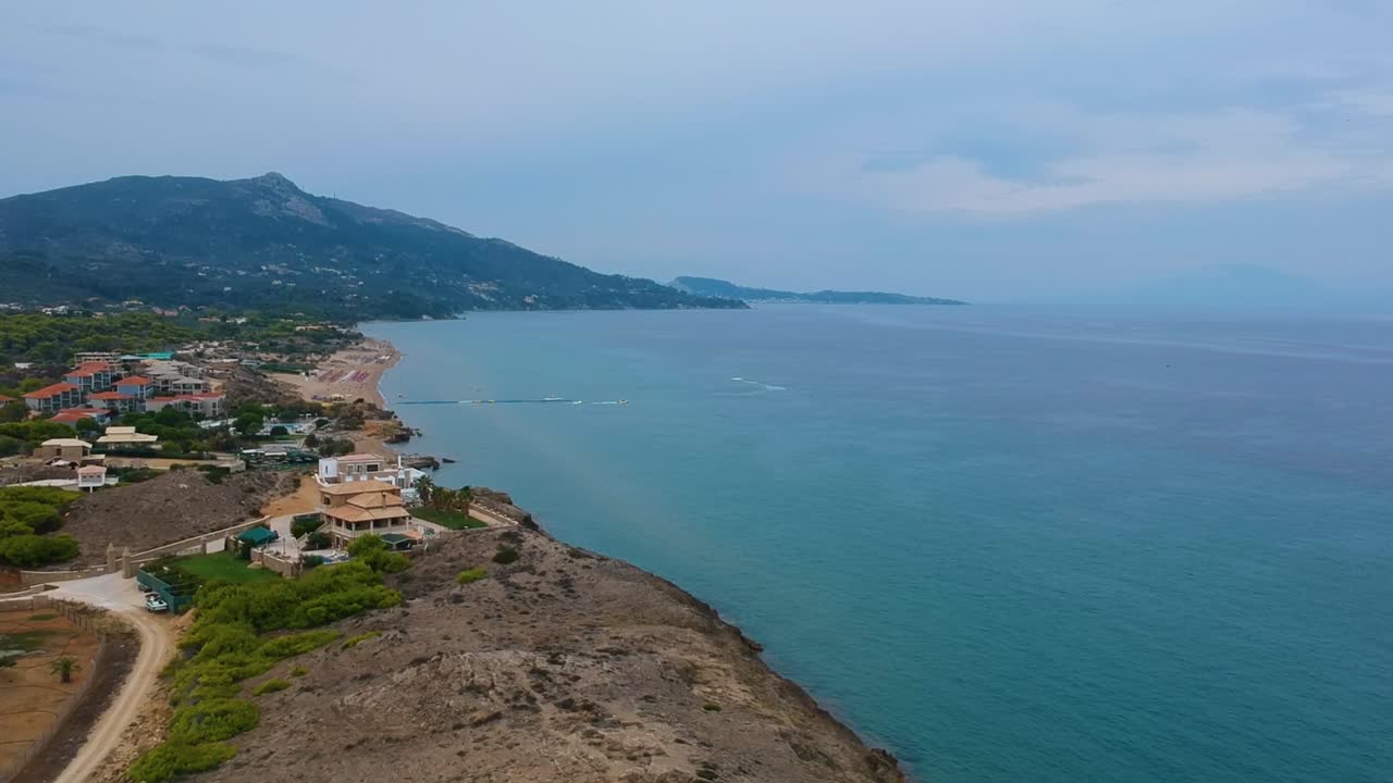 Zakynthos Greece island's Point St. Nicholas cliffs with beautiful beach homes, Aerial drone flyover shot looking northward