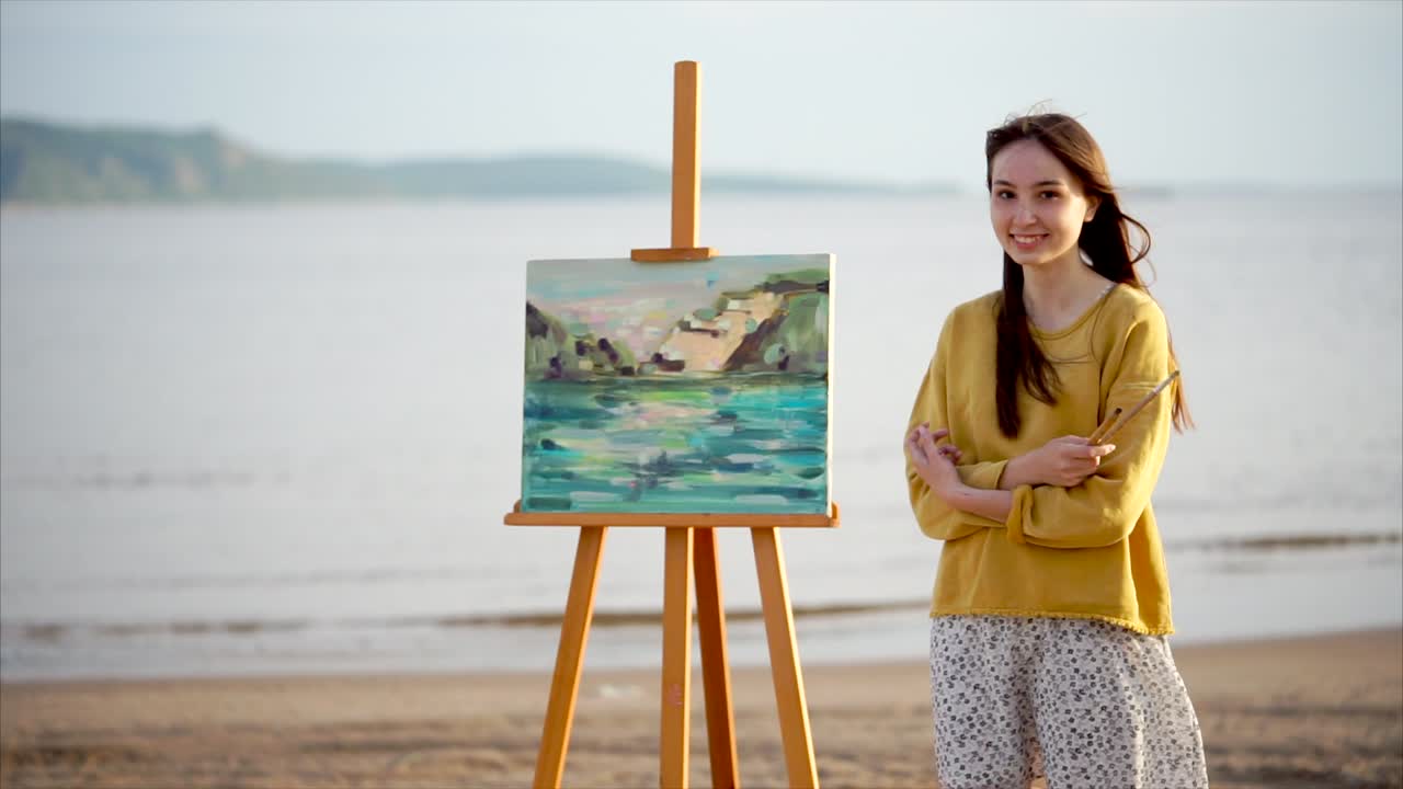 Woman painting a seascape on a beach