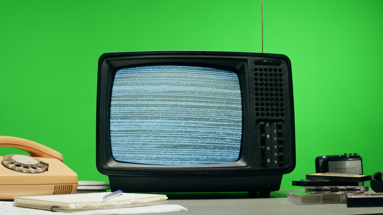 A retro TV displaying static noise, creating a nostalgic vintage atmosphere with blue and green hues.