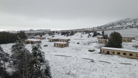cuarteles de base militar abandonados en israel cubiertos de nieve, sobrevuelo de drones, nivel bajo
