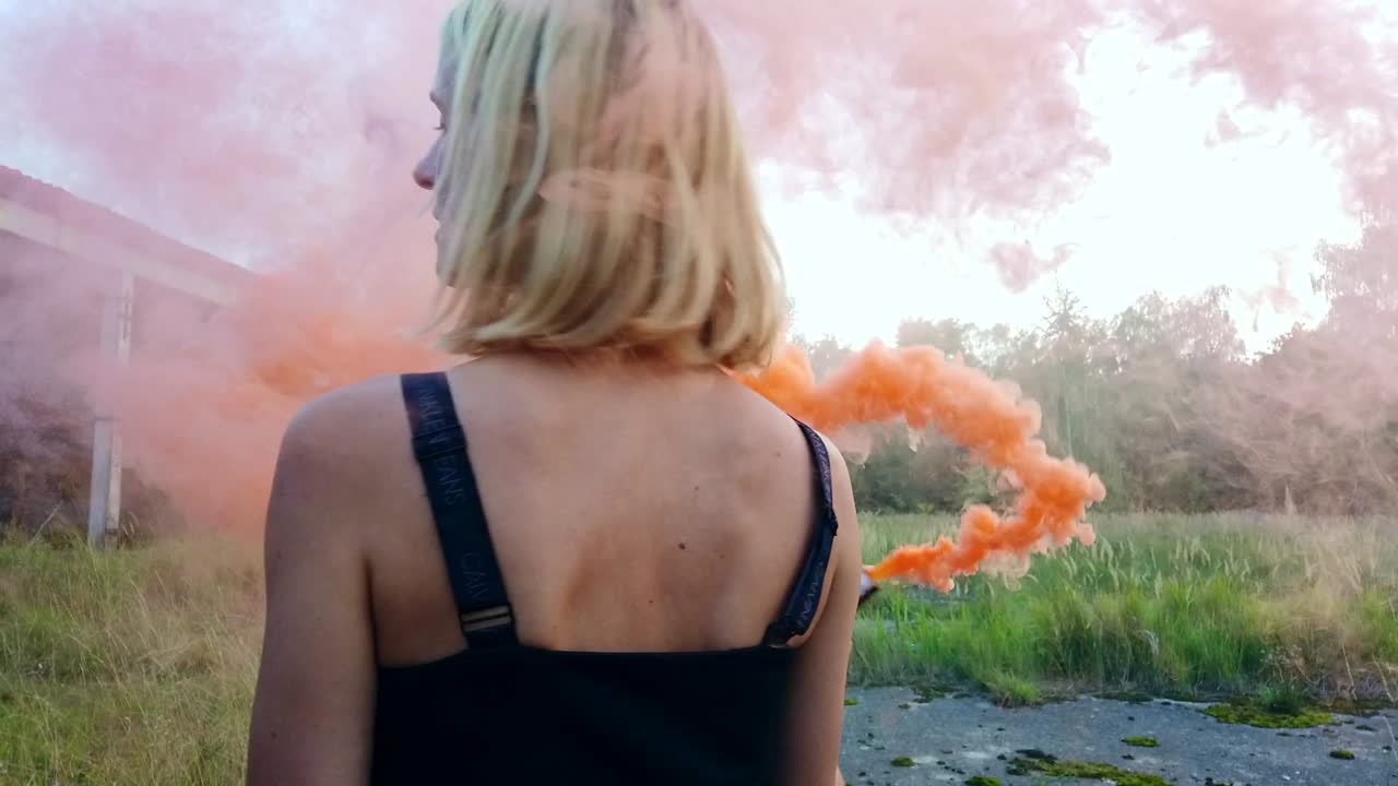Calmer slow motion cinematic shot of a beautiful girl shows back.Colorful fog shooting Russians airplane hangar. Gimbal foto video shoot on lost places in wild nature 1080, 24p by Philipp Marnitz
