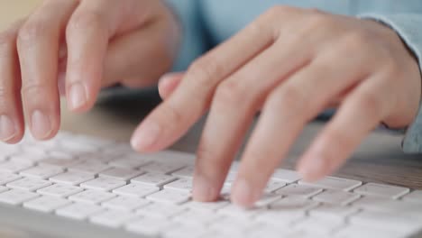 mano de cerca de una mujer de negocios escribiendo teclado computadora de escritorio en la oficina de escritorio