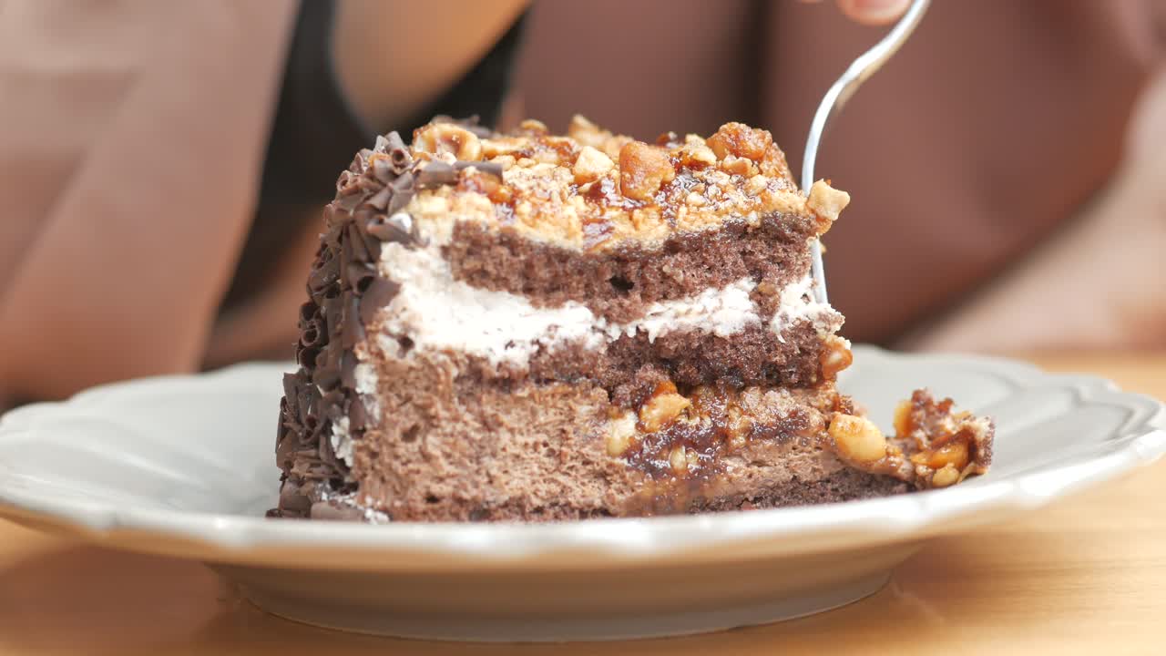 견과류와 함께 초콜릿 케이크 한 조각을 먹는 사람