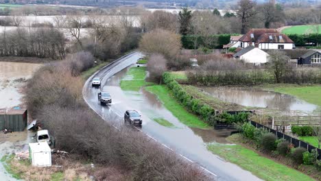 vehicles drive through flooded road abridge essex uk aerial