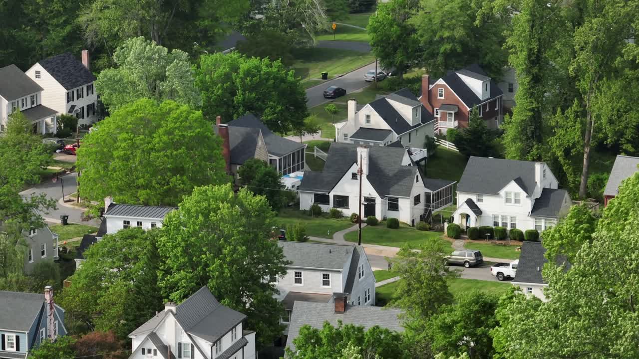 Green Housing area of american town with green trees in springtime. Aerial view. Driving car on street. Quiet district of american town. Film scene. Aerial establishing shot.