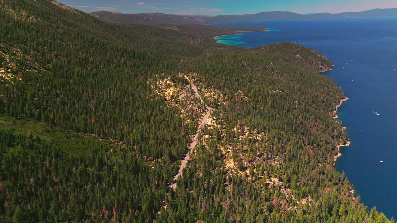Splendid picturesque panorama of Sierra Nevada mountains covered with pine trees. Amazing Lake Tahoe with boats on it. Top view.