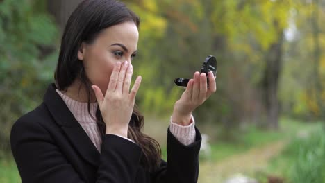 woman looking at pocket mirror