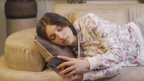 Mujer-Joven-Que-Se-Queda-Dormida-Por-La-Noche-Con-El-Teléfono-En-La-Mano.-Adicción-Al-Teléfono.