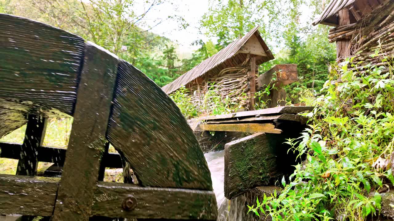 Rushing water power turning nostalgic mechanical wooden mill wheel