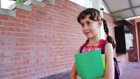 Schoolgirl-walking-in-corridor-at-school