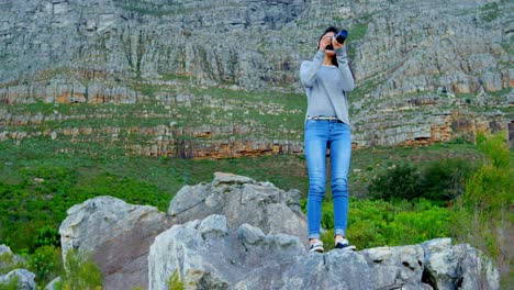 Woman-taking-photo-with-camera-on-the-rock-4k
