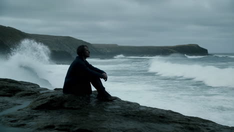 man contemplating the stormy sea