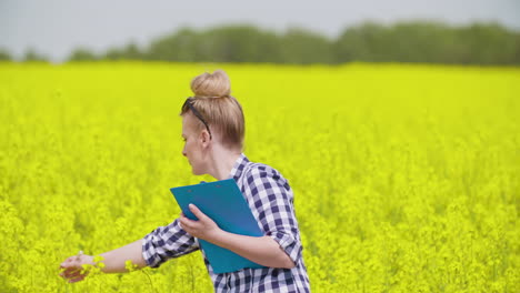 portrait of happy young female farmer in rapeseed field