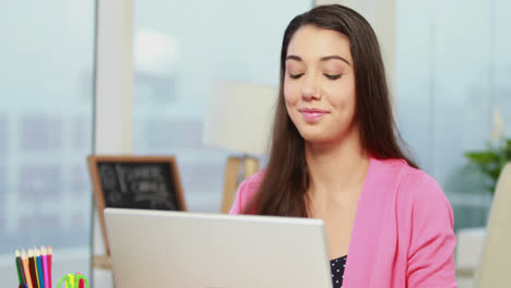 Casual-businesswoman-working-at-her-desk