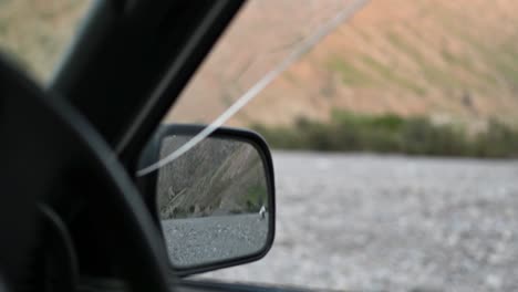 Video-Del-Espejo-Retrovisor-Del-Auto-Mirando-A-La-Gente-Que-Camina-En-El-Terreno-Rocoso-En-Baluchistán