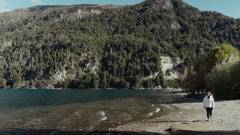 Woman-walks-by-lake-with-waves-and-contemplates-nature