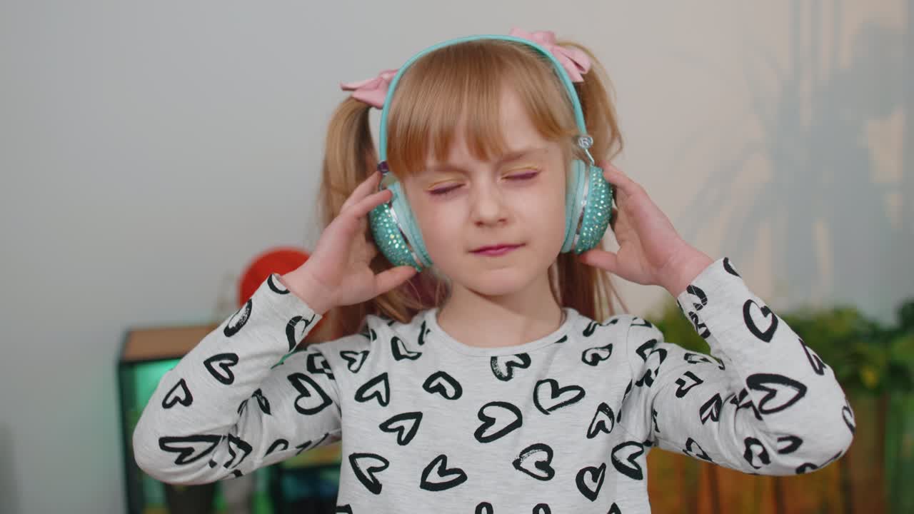 행복한 아이 소녀 아이 헤드폰에 춤추고 뛰어 집에서 혼자 음악을 듣고