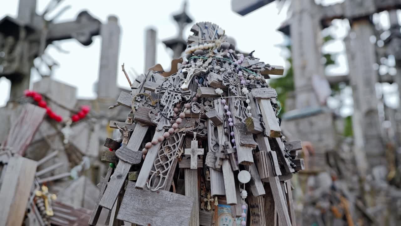 Religious crosses hang on weathered wooden structure at famous Lithuanian shrine