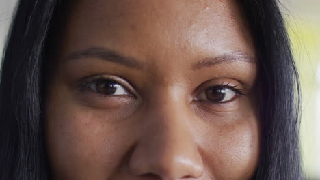 retrato de una mujer de negocios afroamericana mirando a la cámara y sonriendo en la oficina, cámara lenta