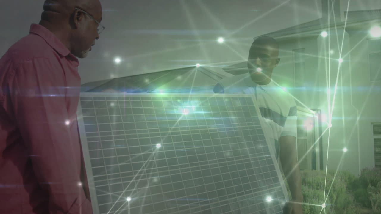 Senior and junior installer carrying solar panel in front yard, showing energy network overlay