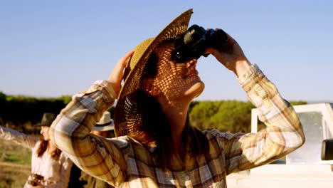 shocked woman holding binoculars during safari vacation 4k