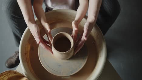 grandmother teaches her granddaughter working on a pottery rotating wheel