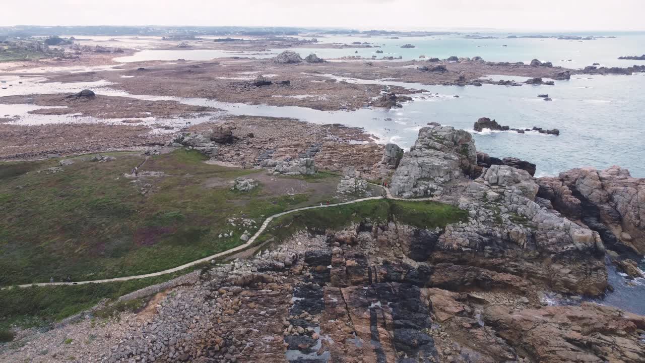Forward Drone Shot over Brittany's Shore at Low Tide Showing Rocky Landscape and Houses, France