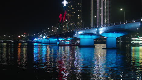 cinematic night view of tran thi ly bridge over han river and cruise sailing in da nang city of vietnam illuminated with lights