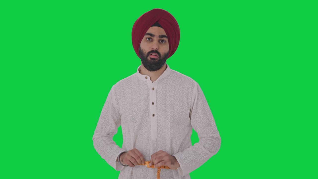 Uomo indiano Sikh triste che misura la vita con un metro a nastro, schermo verde.