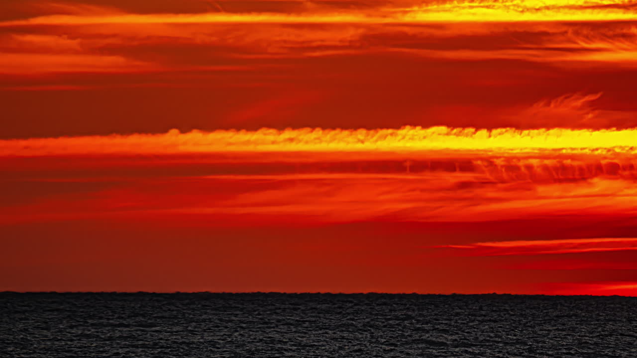 바다 위에서 불타는 해가 지는 것