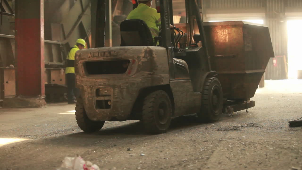 un cargador basculante recoge basura en un centro de reciclaje 2