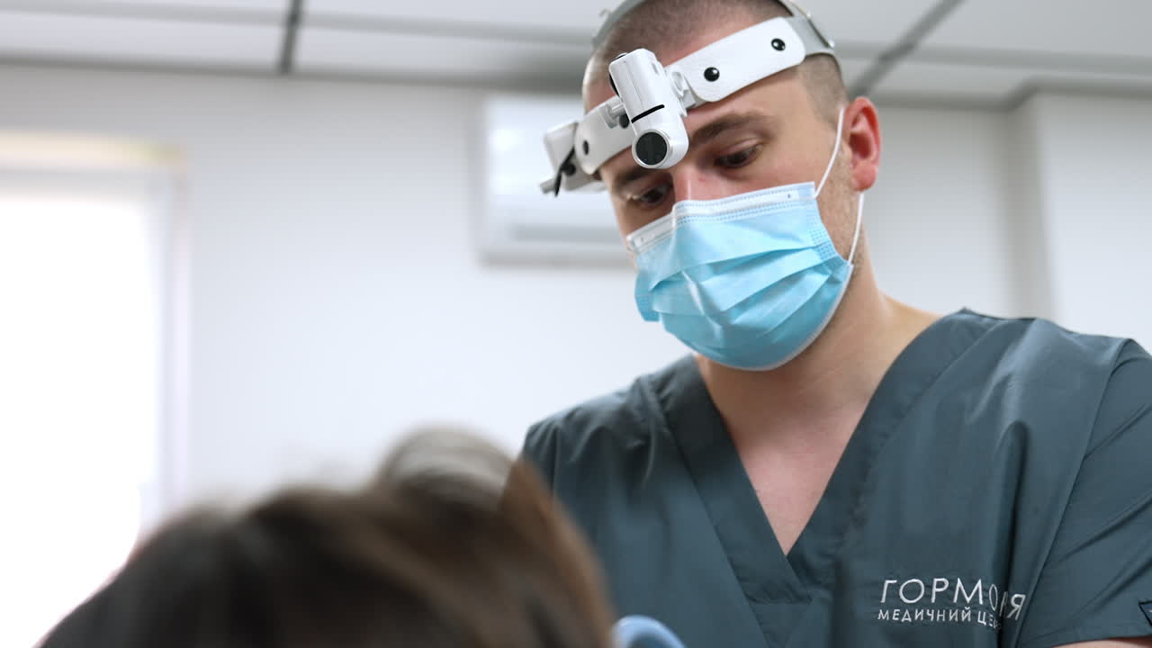 Kyiv, Ukraine, 2 August 2025: Doctor focuses during exam. A doctor focuses carefully while performing a detailed ENT examination