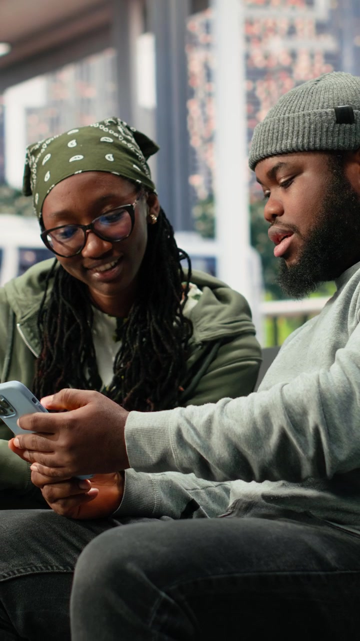 Young Couple Looking at Smartphone Together in Public Space