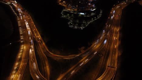 Lapso-De-Tiempo-Del-Dron-Del-Paso-Elevado-Nocturno-Que-Se-Alimenta-Desde-Una-Autopista-Costera-Llamada-&quot;circuito-De-Playas&quot;-Hacia-Un-Camino-Cuesta-Arriba-Llamado-&quot;bajada-Armendariz&quot;-La-Cámara-Cardán-Se-Inclina-Hacia-Arriba