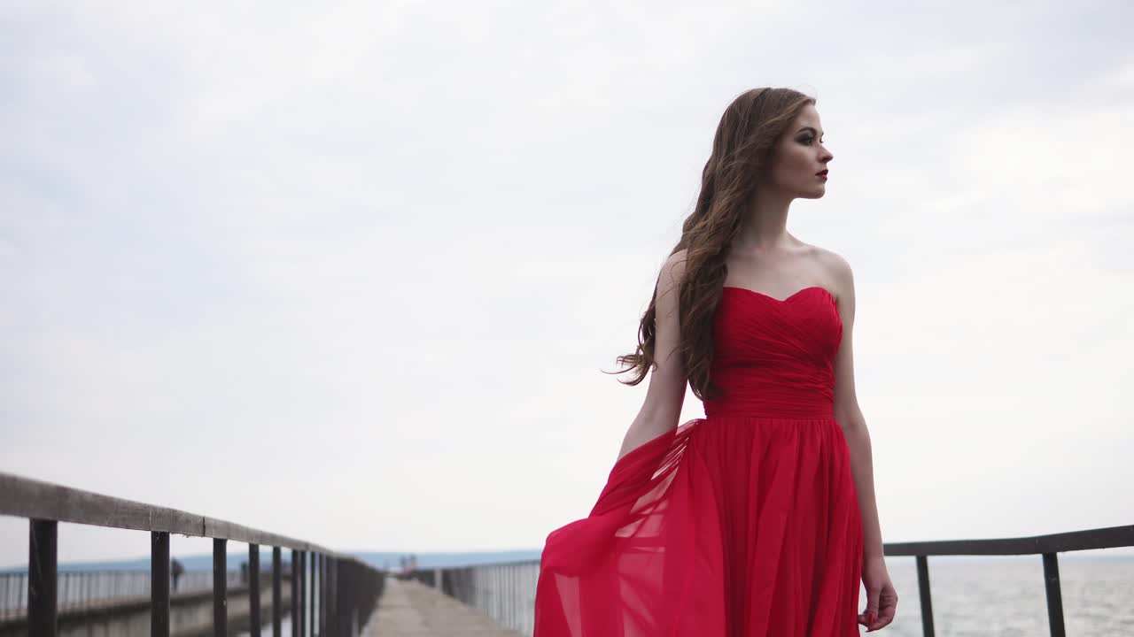 Woman in Red Dress on a Bridge by the Sea