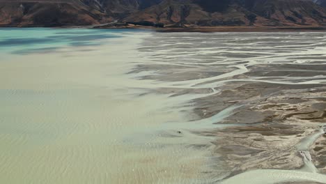 Cinematic-aerial-view-over-Tasman-river-delta-entering-Lake-Pukaki