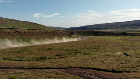 Vista-De-Pájaro-Siguiendo-La-Conducción-De-Automóviles-Islandia-Tierras-Altas-Cubiertas-De-Musgo-Y-Fangosas-Explorando-El-Desierto.-Drone-View-Vehículo-4x4-Acelerando-Camino-De-Polvo-En-El-Campo-Islandés.-Explorando-El-Concepto