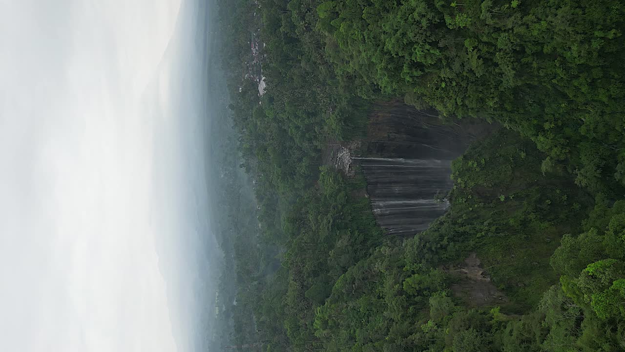 el formato vertical se acerca desde el aire al cañón de la cascada de tumpak sewu en java.