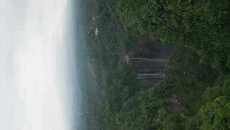 vertical format aerial approaches tumpak sewu waterfall canyon on java