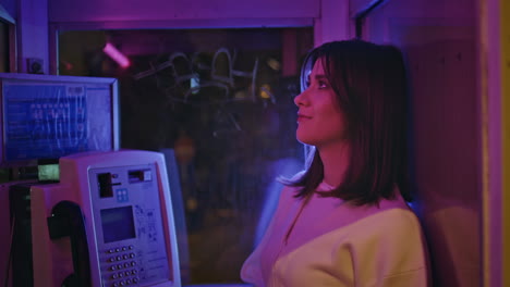 happy woman resting phone cabin enjoy nightlife alone in neon lights closeup