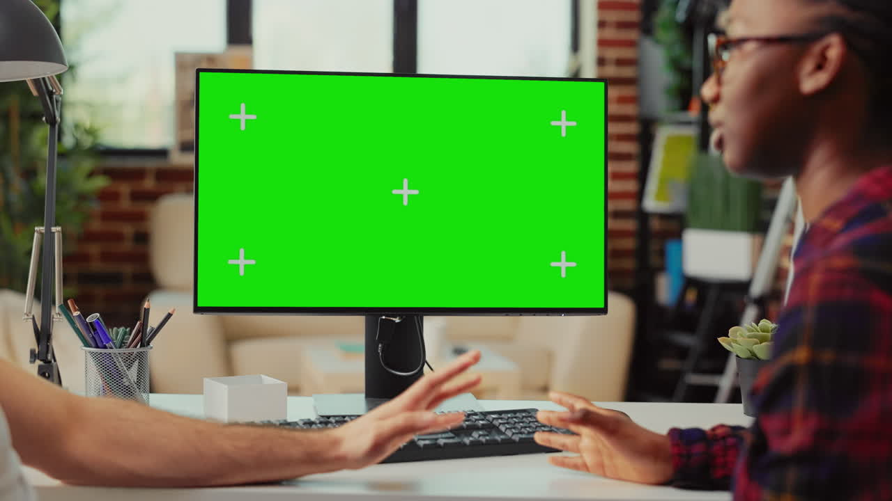 Multiethnic team working on computer with greenscreen at home