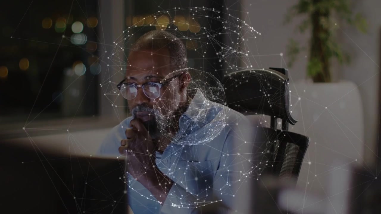 African American man working in office, studying rotating data globe on monitor, wearing eyeglasses