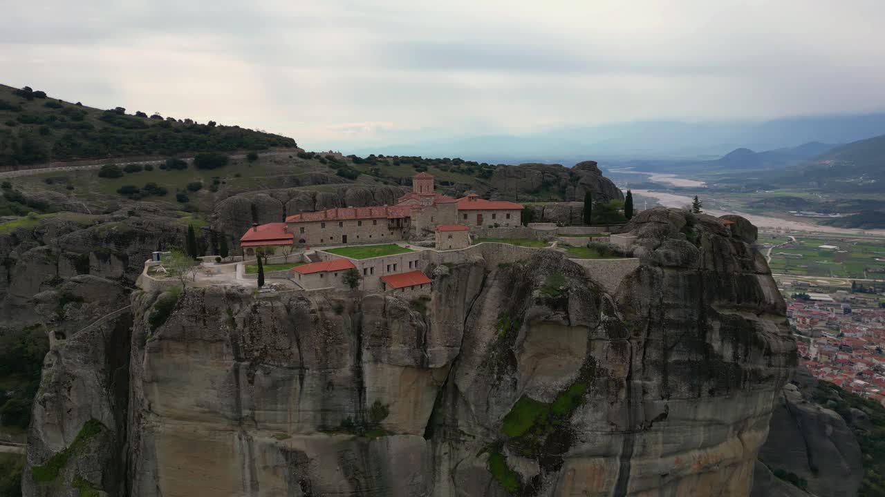 Aerial descent of Great Meteoron Monastery on rocky summit in Meteora, Greece