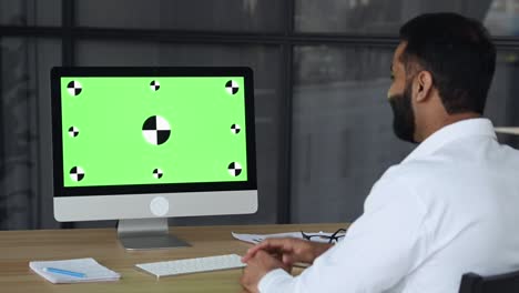 green screen on computer. online business briefing. indian successful businessman having virtual online meeting with diverse multinational colleagues via video call using laptop, discuss ideas, plans