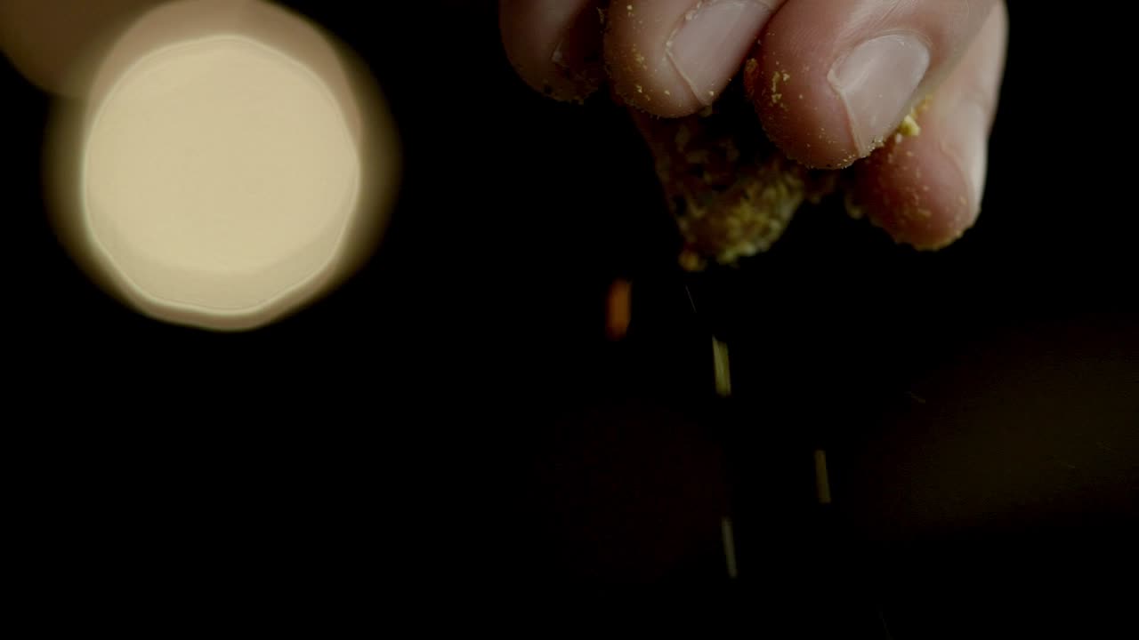 Macro slow motion closeup with fingertips sprinkle seasoning