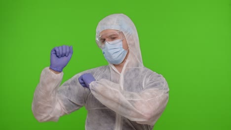 Medical-worker-doctor-in-PPE-protective-suit-dancing,-celebrating-victory-on-chroma-key-background